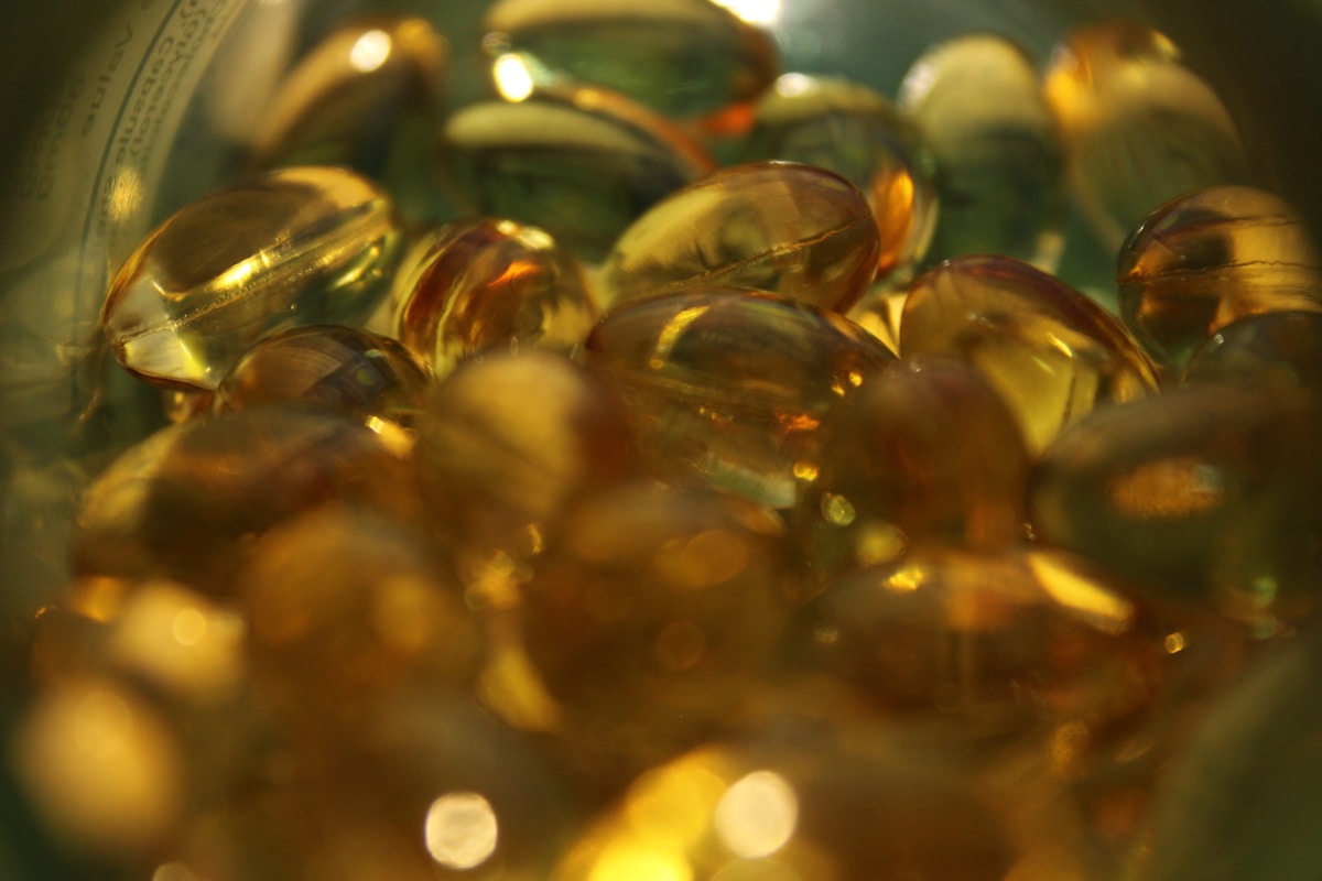 Assorted vitamin capsules in a glass bowl, illustrating liposomal and softgel supplement formats.